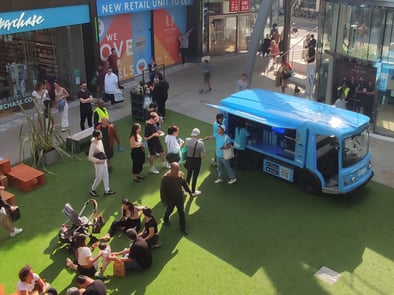 A crowd gathers around the Zapp milk float, with samples given out.