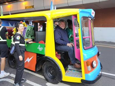 The side of the Birmingham Pride parade electric milk float, with a passenger smiling.