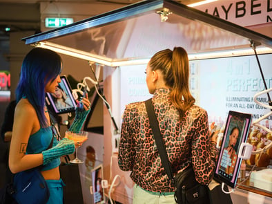 The L'Oreal and Maybelline Piaggio Ape with two women showing interest.