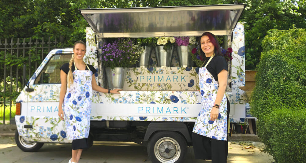 Primark Italian Piaggio Ape, with flowers in display inside.