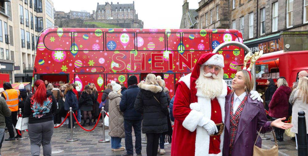 Santa and a guest pose in front of the SHEIN festive campaign bus