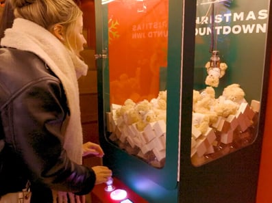 A guest enjoys the claw machine in the SHEIN Xmas bus