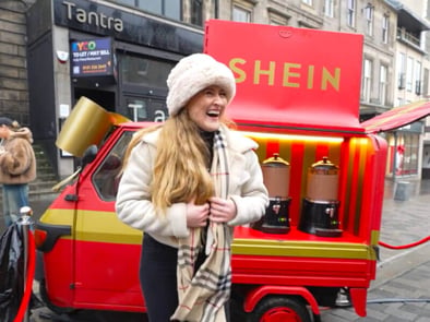 A woman poses happily near the SHEIN Piaggio Ape