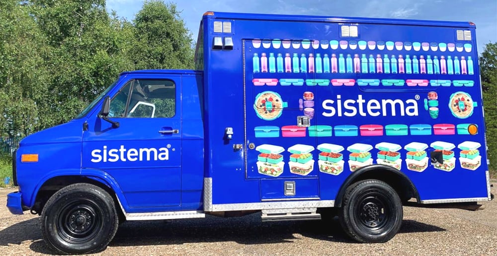 The blue Sistema American ambulance, viewed from the side.